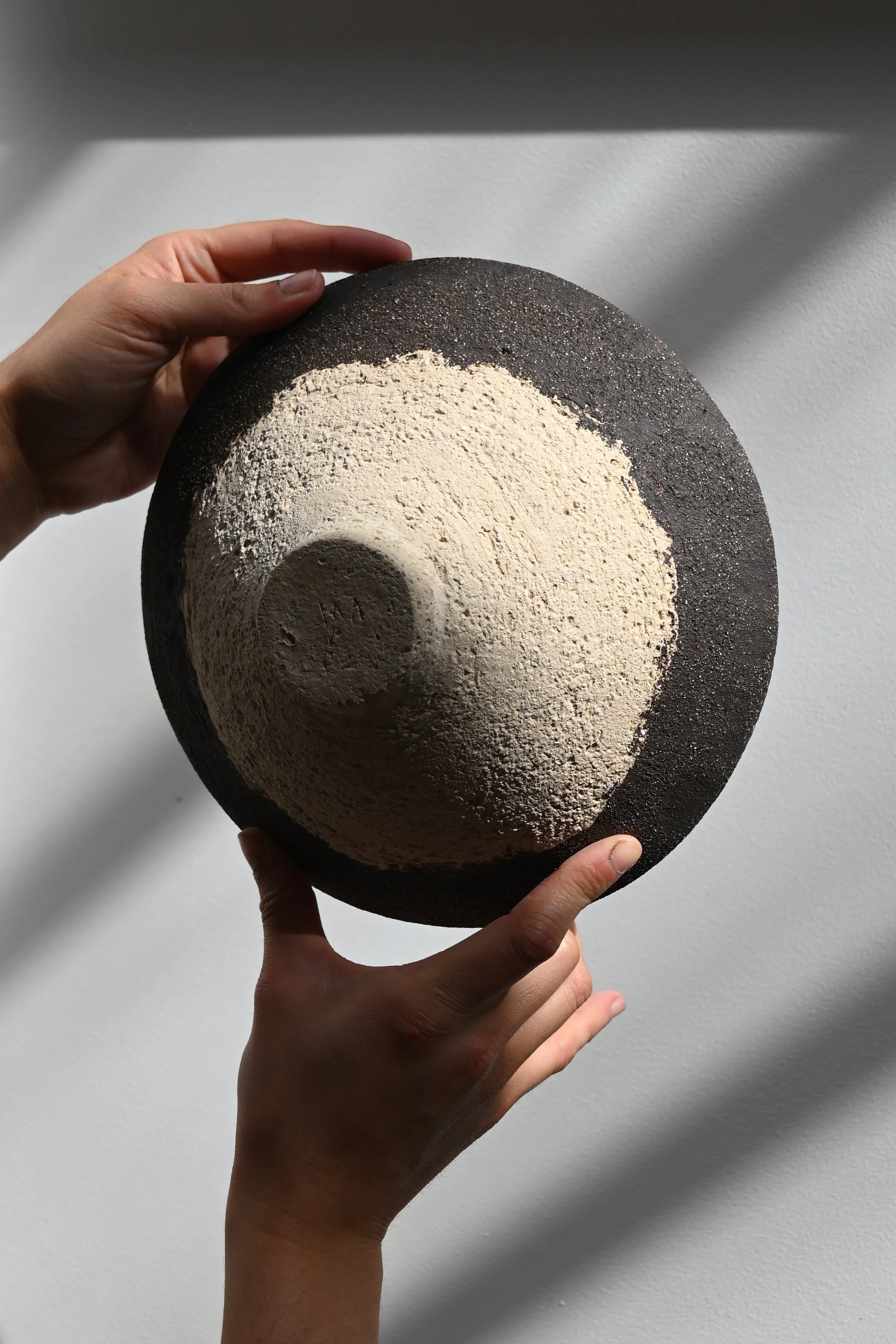 Belle photographie d'un plat à ramen crée par Jeanne Yaa Stenmanns au modelage en grès noir et en grès blanc. 