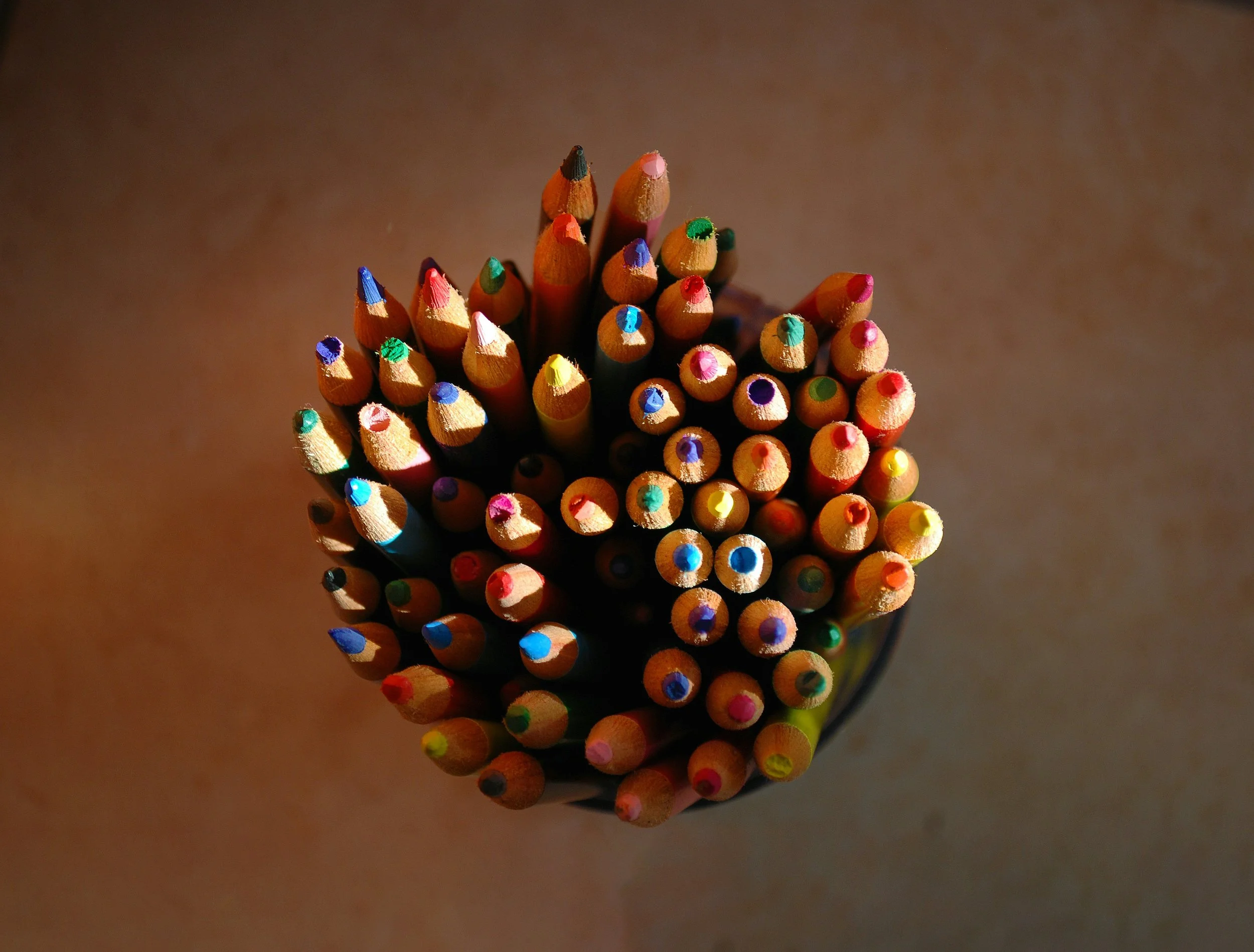 Top-down view of colourful pencils — representing creative expression, art-based child therapy, and emotional support at REST in Nairobi and London