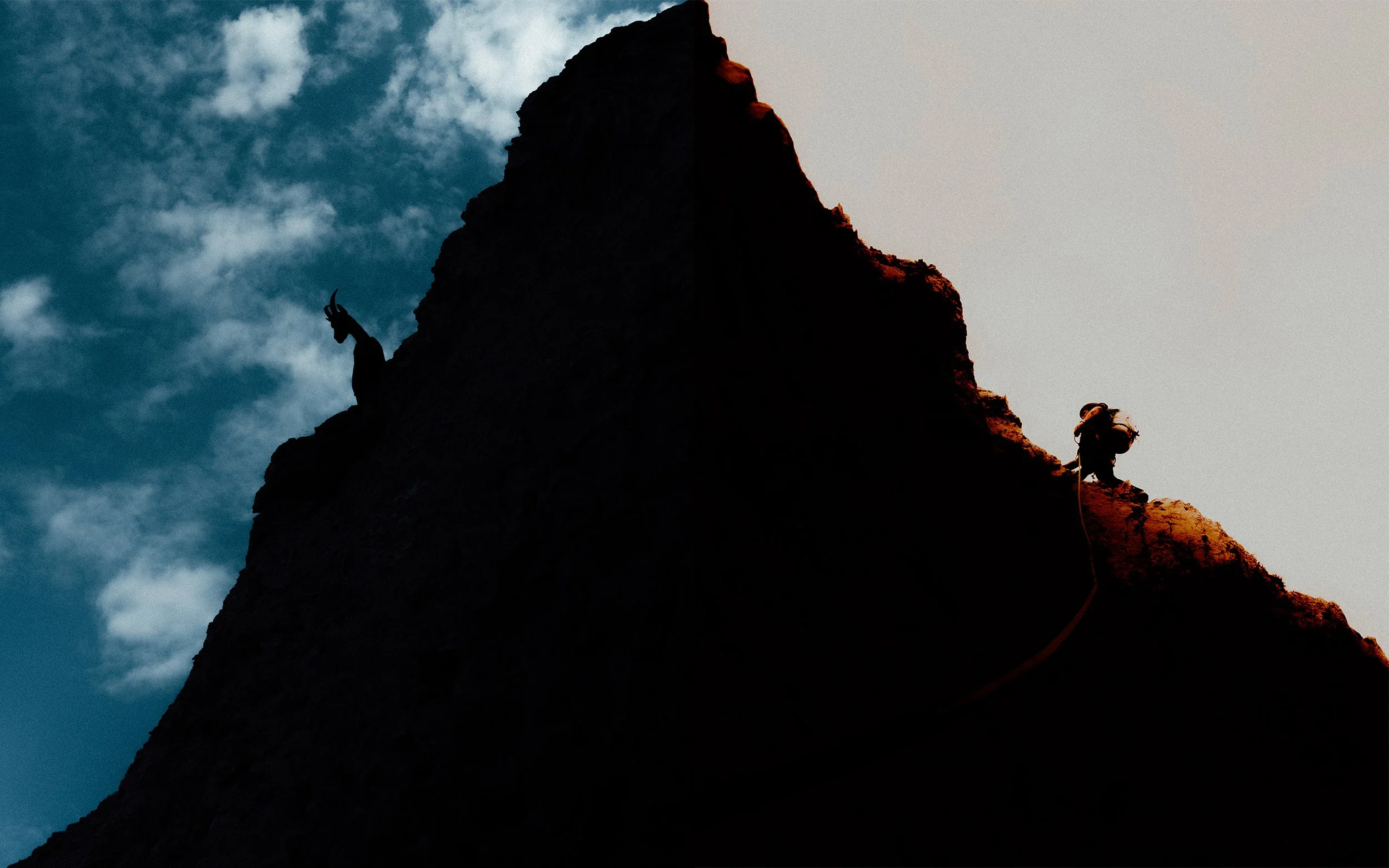 Silhouette d'une montagne avec deux alpinistes qui escaladent, ciel orageux en arrière-plan.