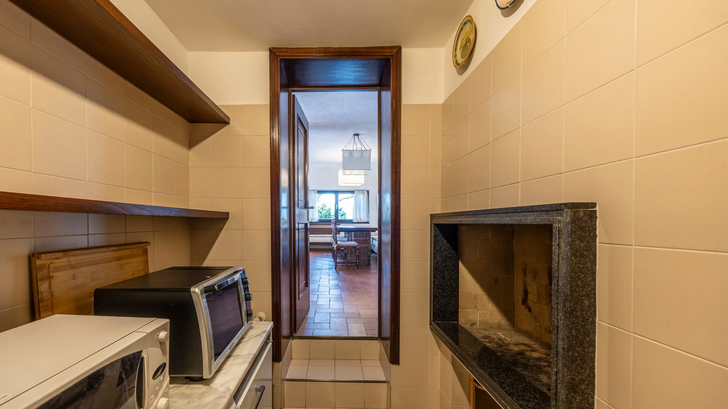 Vista dalla Cucina verso la zona pranzo con in primo piano la zona barbecue.