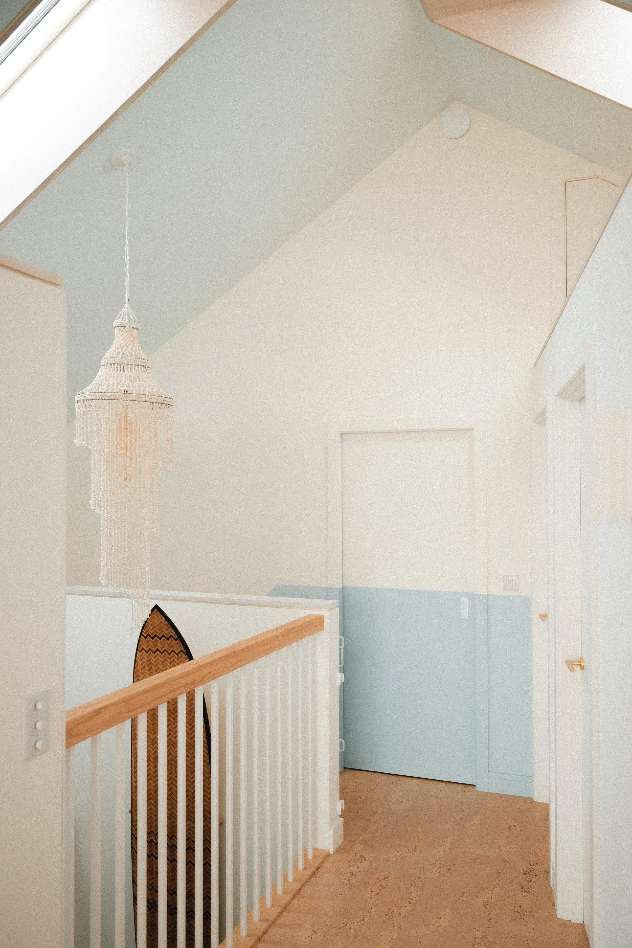 hallway with surfboard hanging, painted in two tone