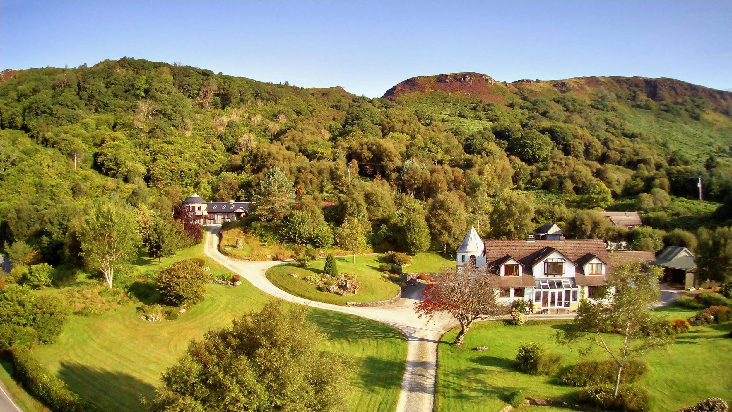 Greenwood's main house and two cottages beneath the hills