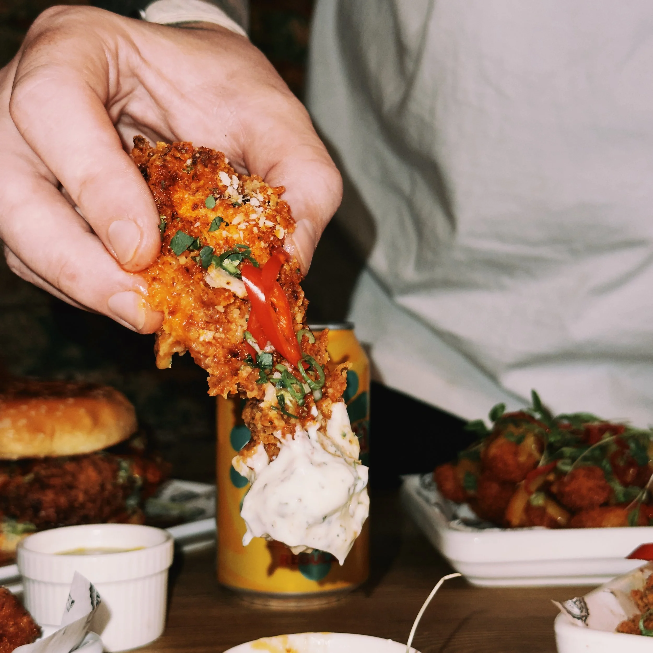 From above hands of unrecognizable woman rubbing aromatic spices into piece of raw meat over parchment paper
