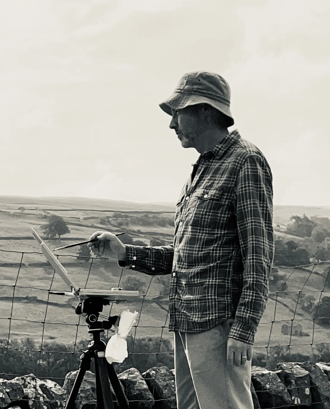 Anthony Lofthouse painting plein air with a landscape of rolling hills of the Yorkshire Dales.