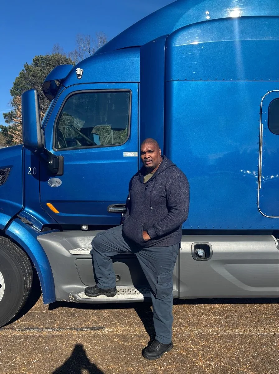 Dave Pruitt, founder of Legacy CDL Academy, beside a blue semi-truck