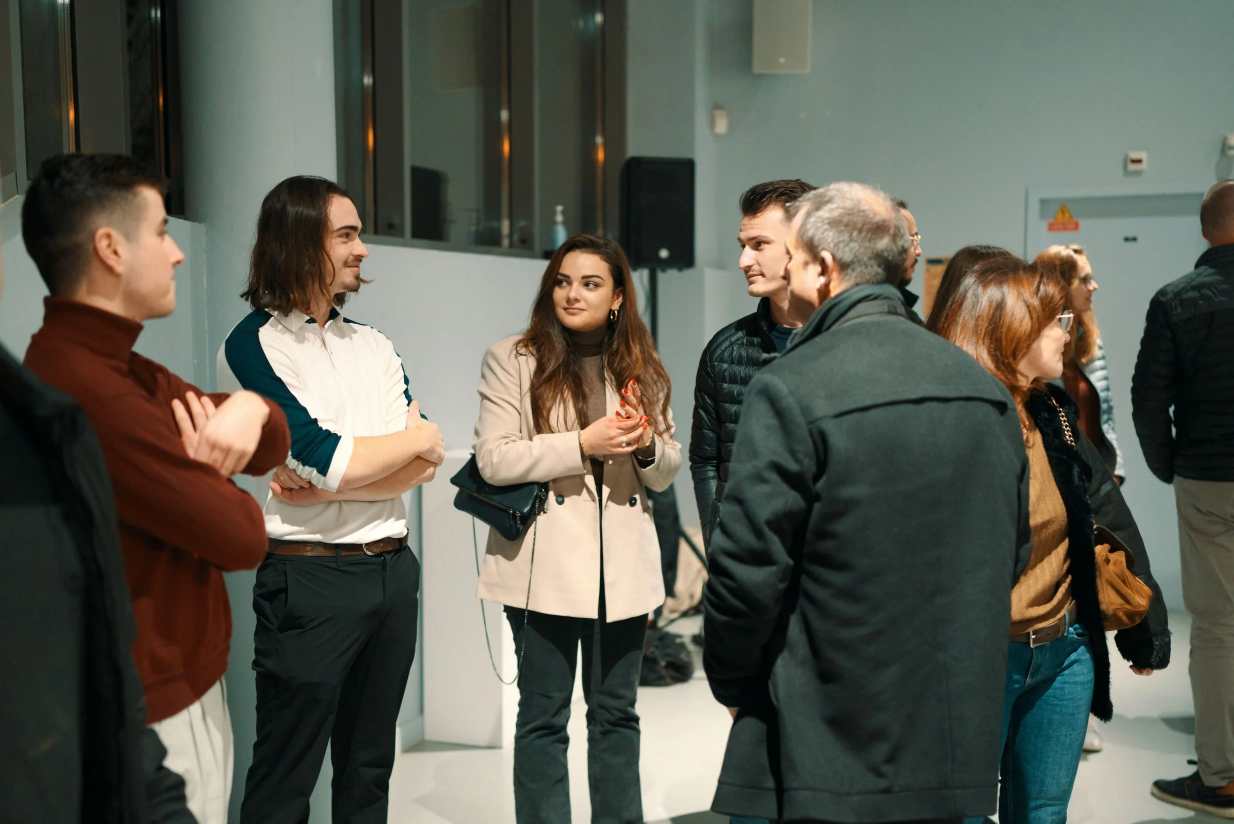 Groupe de personnes en conversation dans un espace intérieur moderne.