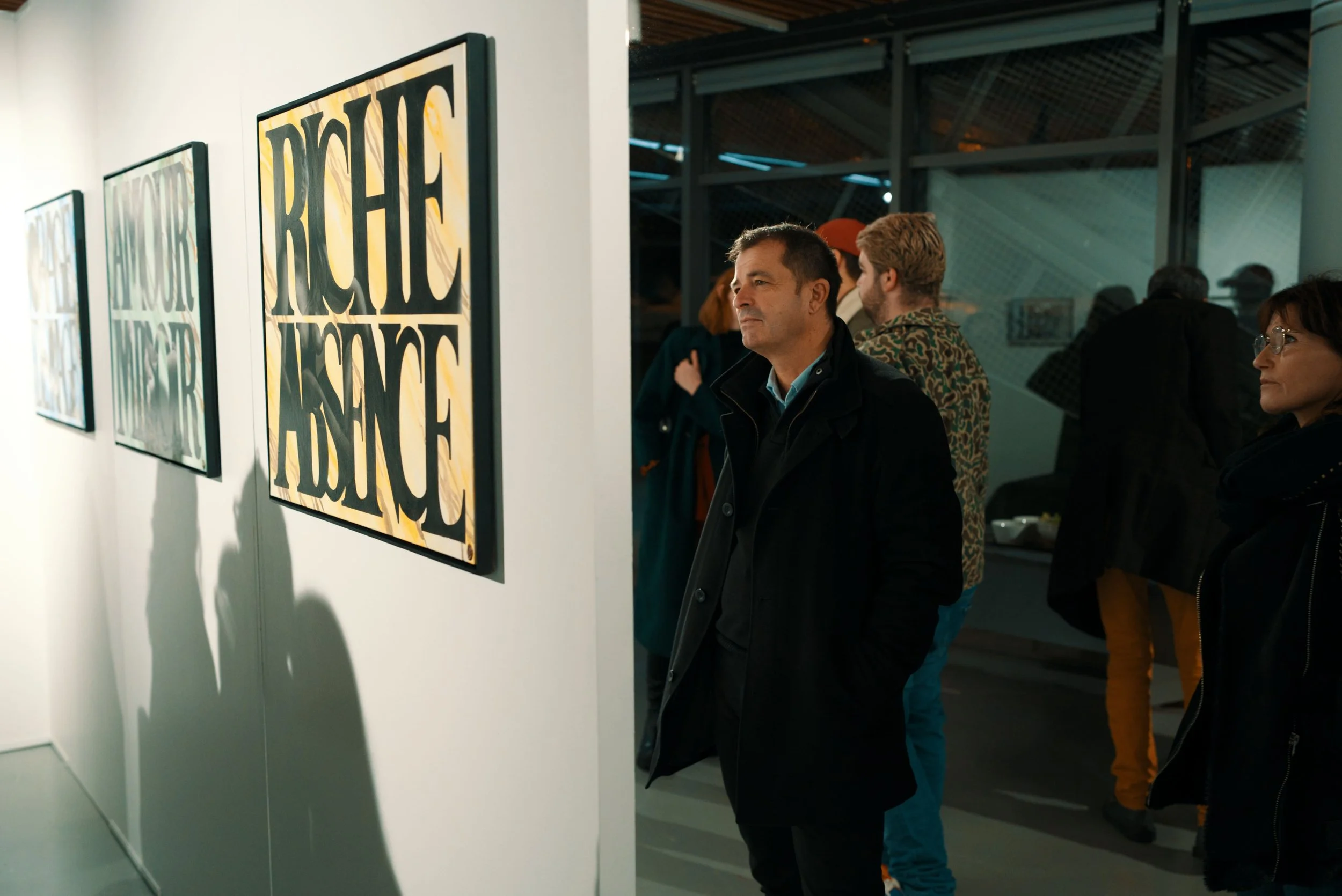 Visiteurs observant des œuvres d'art dans une galerie.