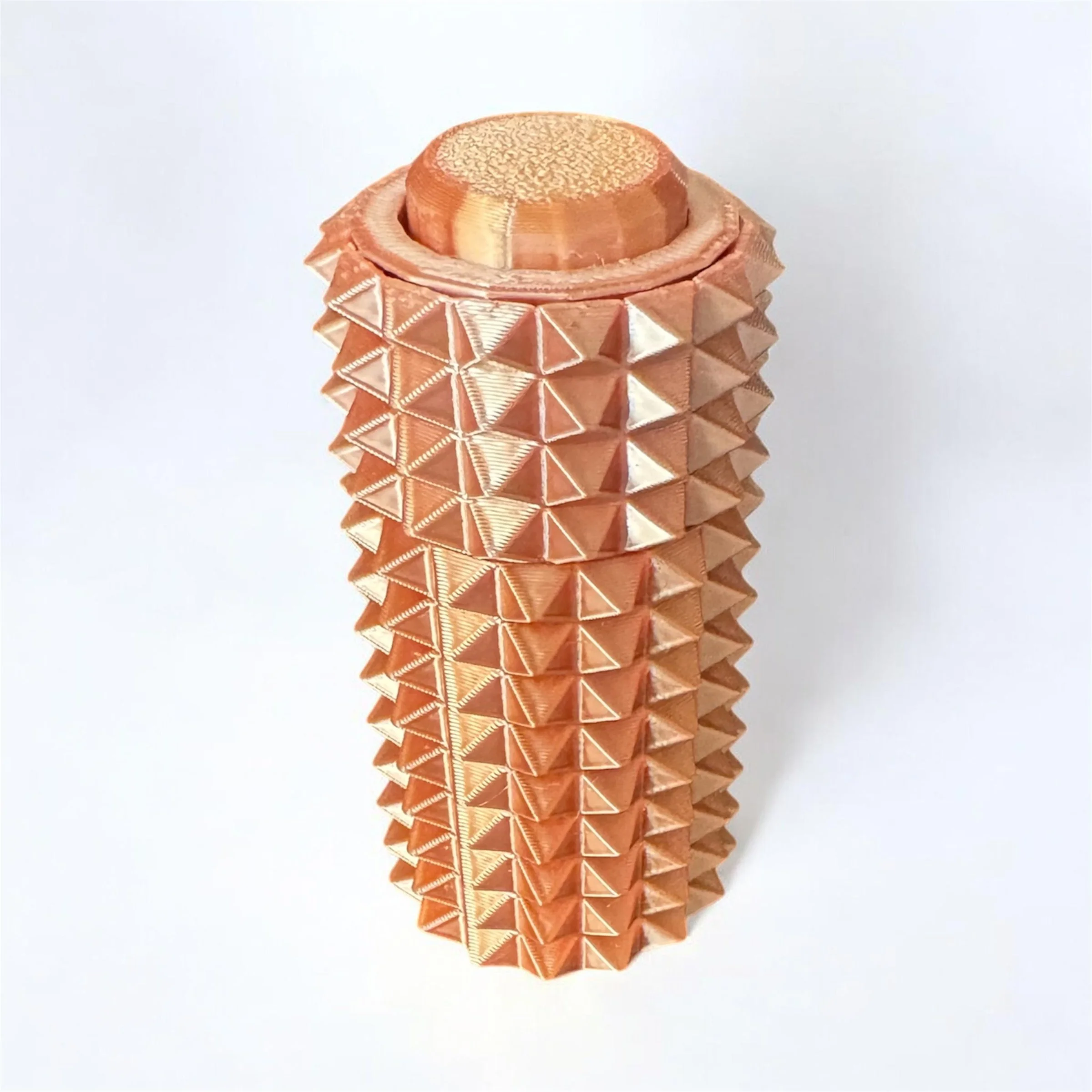 Close-up of a decorative brown paper craft with a geometric pyramid pattern stacked vertically.