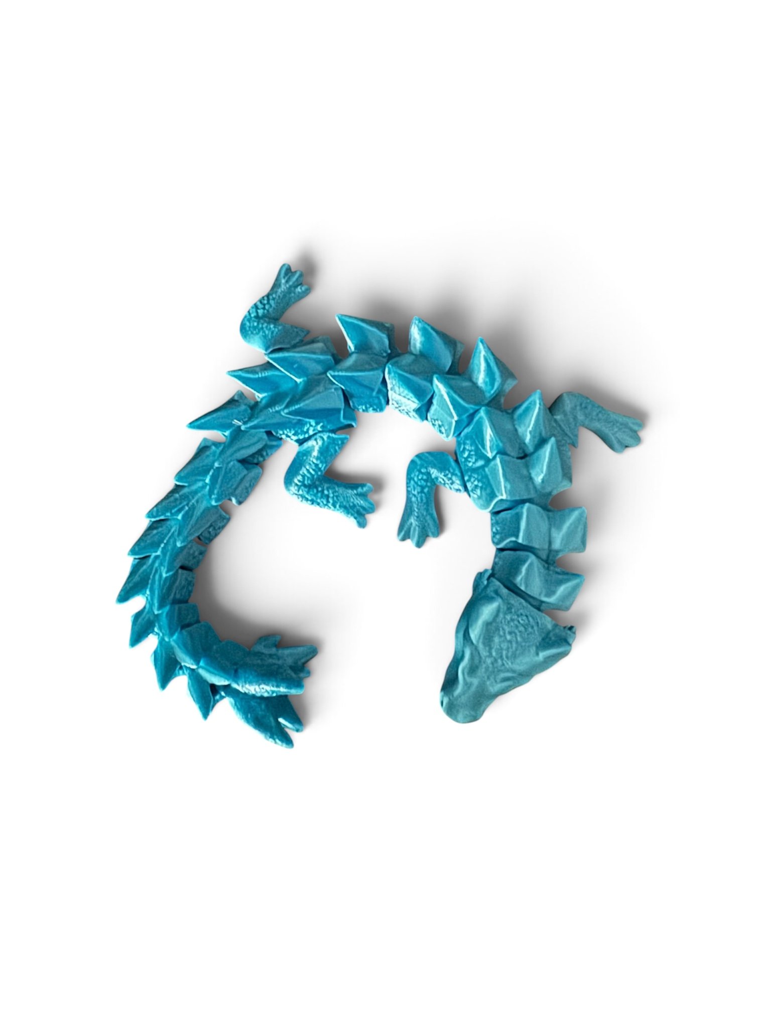 Blue crumpled paper resembling a dragon or mythical creature against a white background.