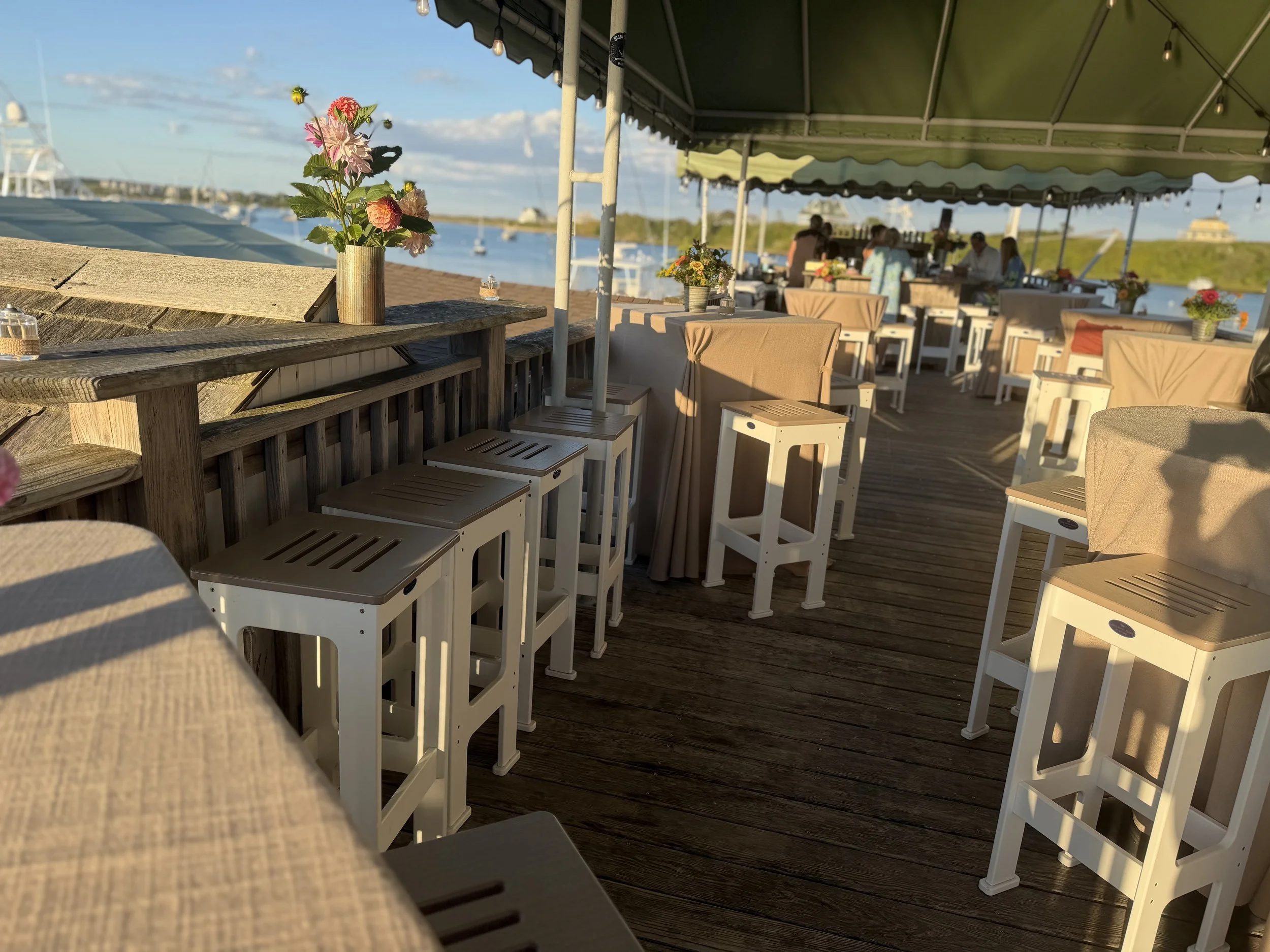 Waterfront wedding reception deck on Block Island set with flowers, planned by Merci La Vie