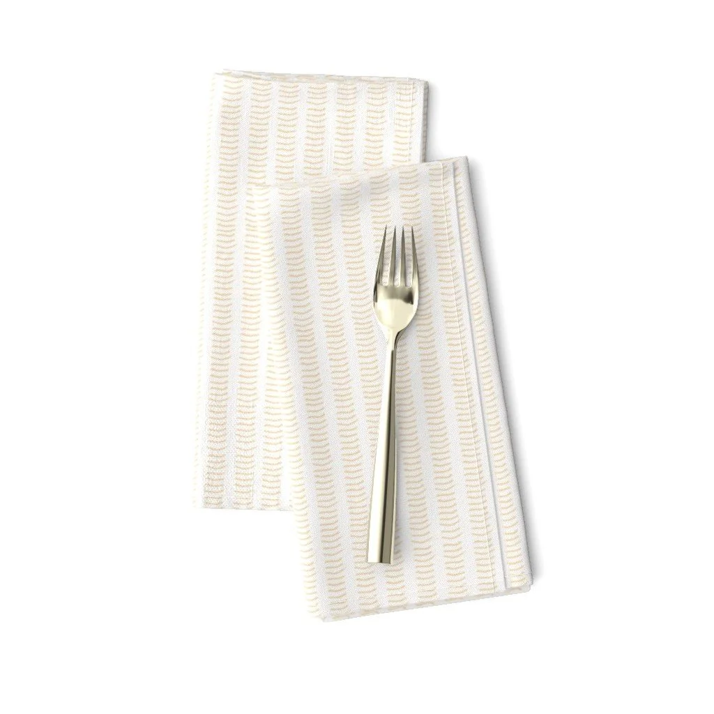 Cream cloth napkins with fine honey colored hand drawn brush marks in a repeating pattern.