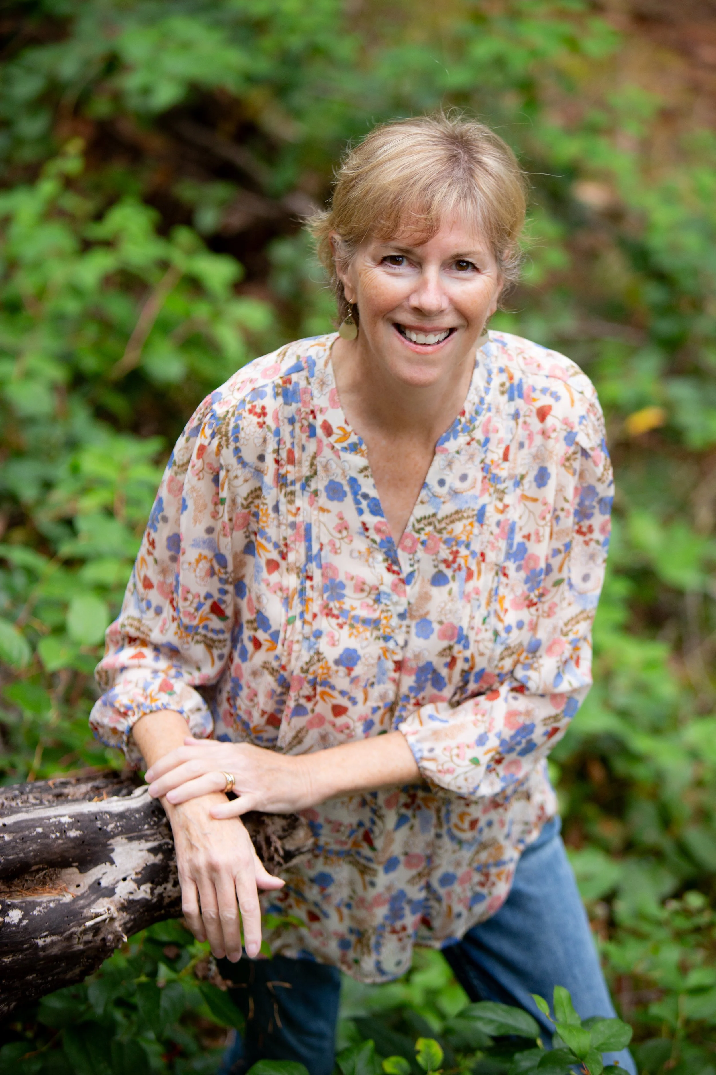 Artist and designer Kelly Edmonds of Curious Shapes Studio photographed outdoors in a forest setting.