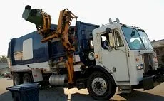 Side-loading garbage truck with its automated arm raised