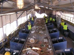 Workers sorting materials on a recycling picking line