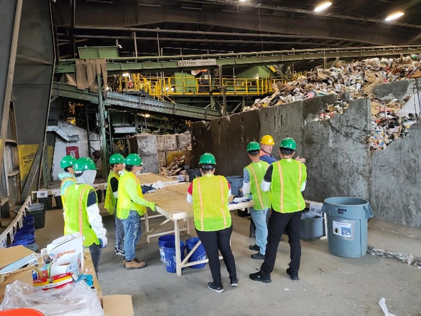 GBB team members in hard hats and safety vests at a waste sorting table inside the Baltimore County Central Acceptance Facility MRF