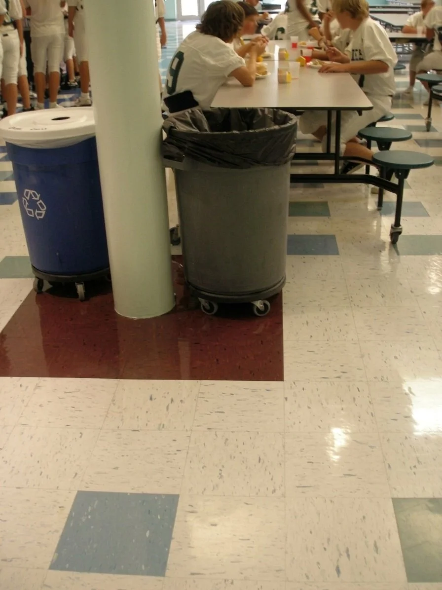 Recycling and trash bins beside a cafeteria table in a Stafford County public school
