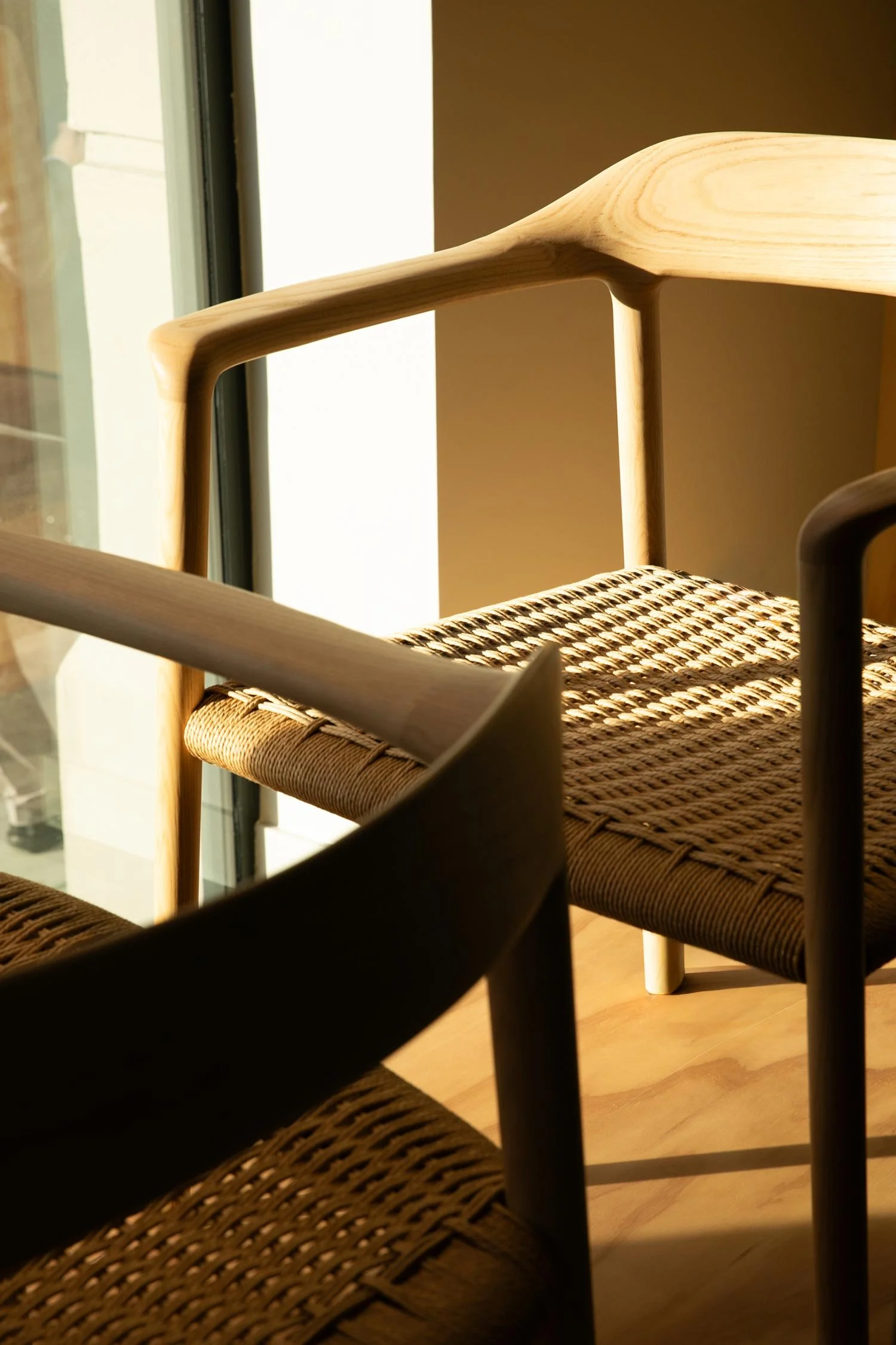 Close detail of woven and wooden armchairs from the Andreu World furniture collection.