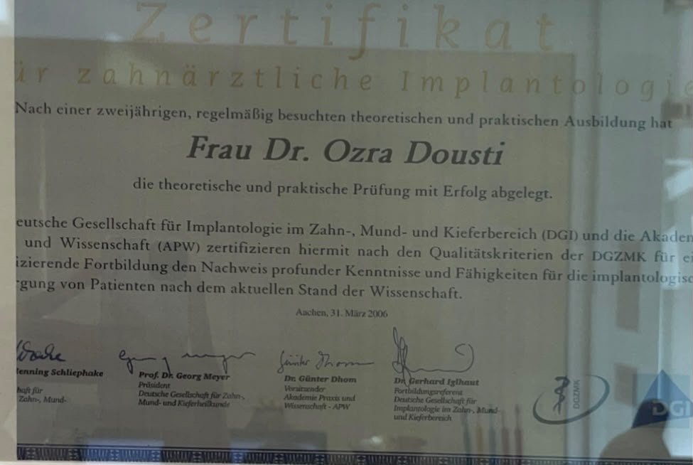 Zertifikat für zahnärztliche Implantologie, ausgestellt an Frau Dr. Ozra Dousti, datiert auf den 31. März 2006 in Aachen.