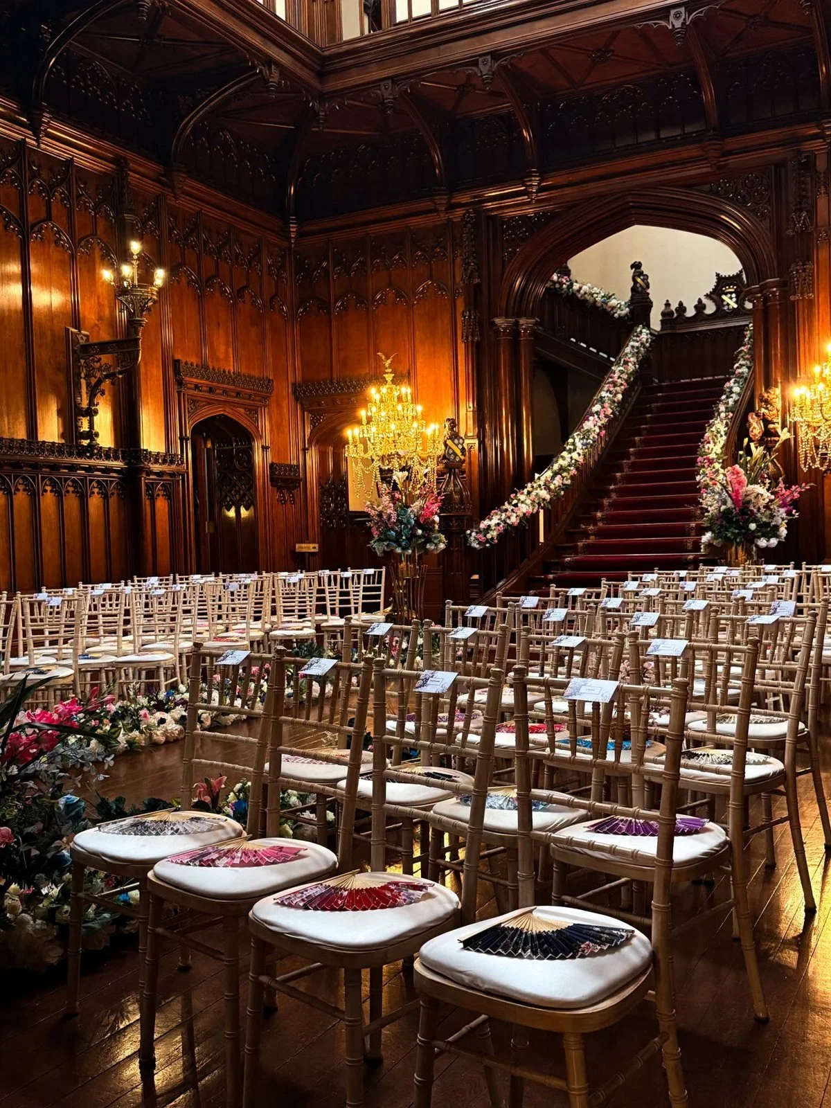 Gold chairs lined up in front of the grand staircase at Allerton Castle