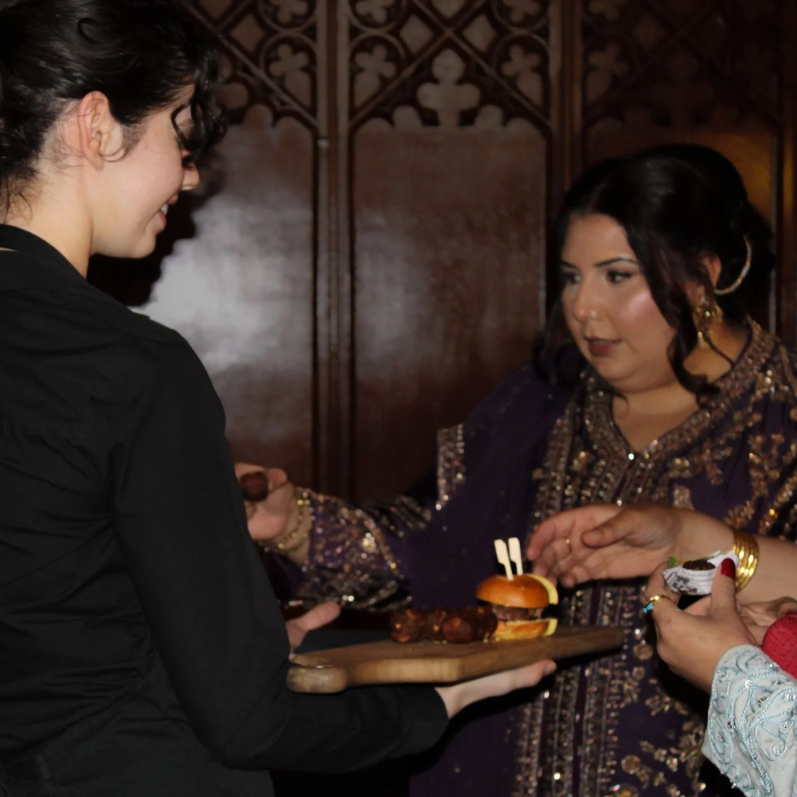Taste Cuisine waitress offering a canapé slider to a guest at Allerton Castle