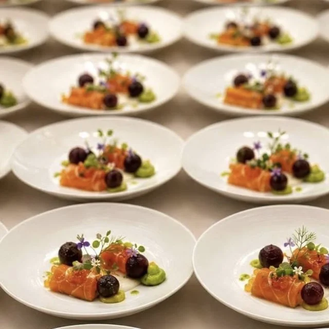 Rows of elegantly plated salmon starters set for a wedding breakfast
