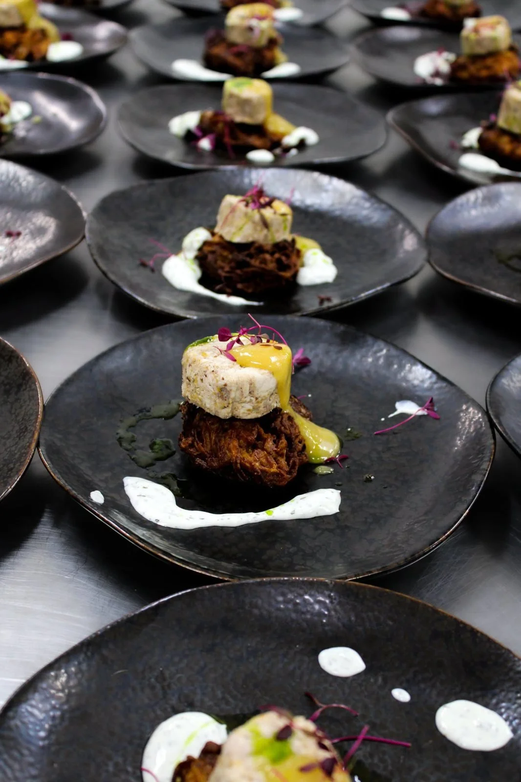 Starter plates of terrine on rösti with sauce, plated for a wedding breakfast