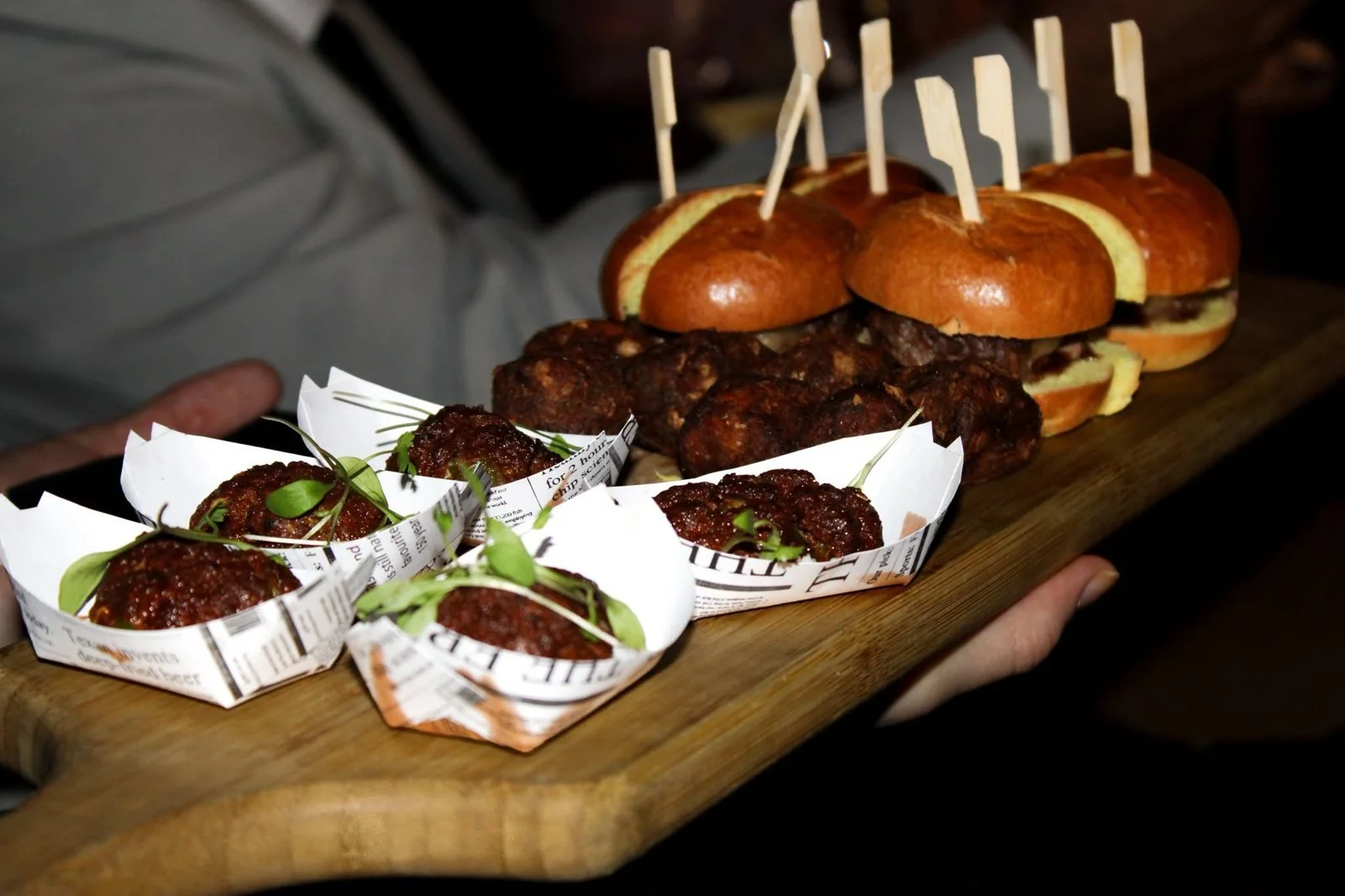 Sliders and meatballs served on a wooden board at a wedding drinks reception