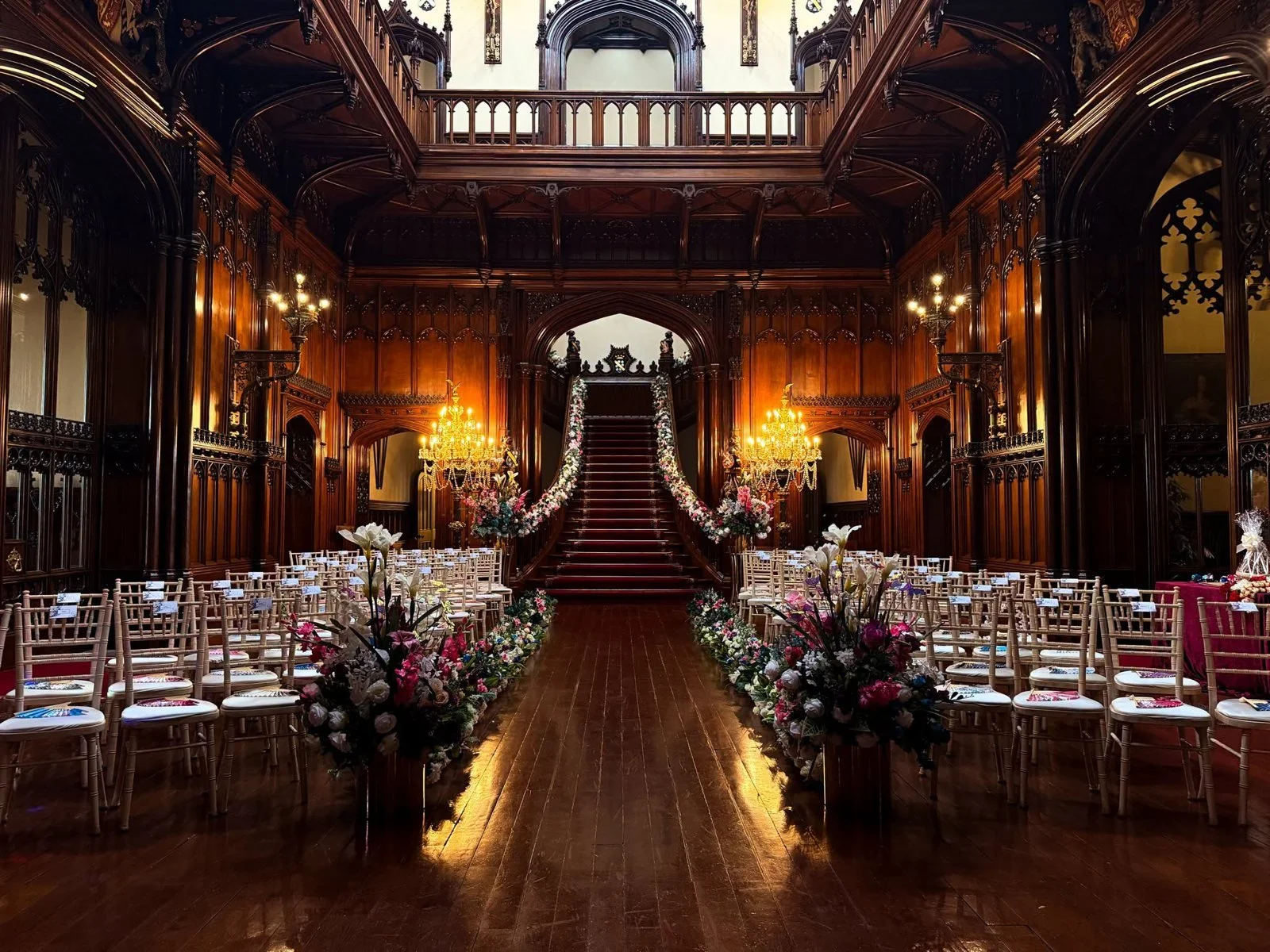 The Great Hall at Allerton Castle set with gold chairs and flowers for a wedding ceremony