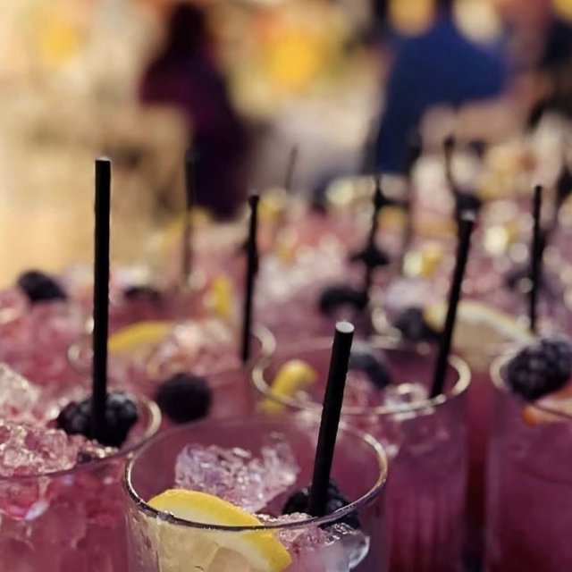 Rows of blackberry and lemon cocktails ready to be served at a party
