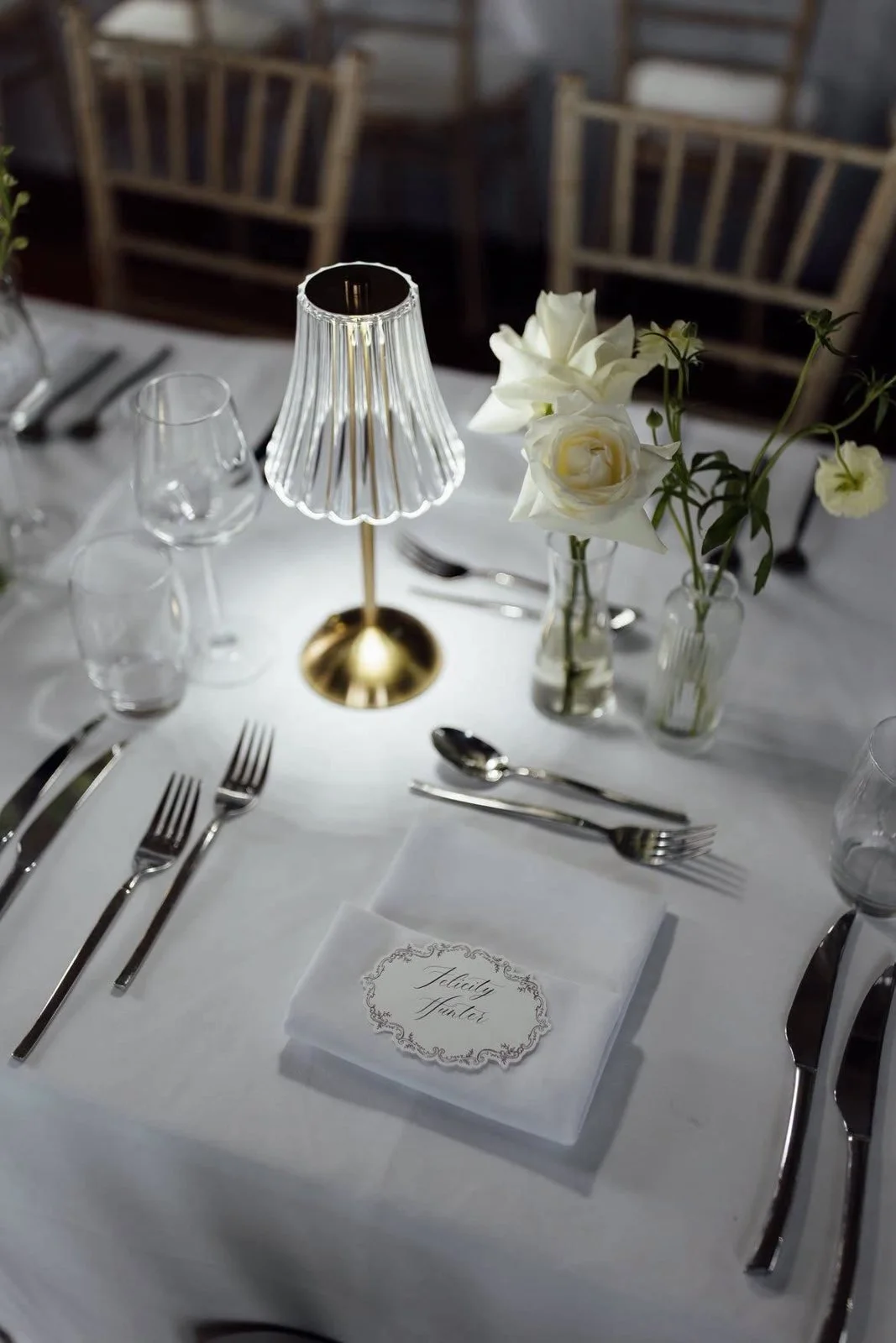 Close-up of a wedding place setting with cutlery and a personalised name card