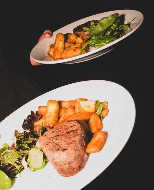 Fillet steak main course with chunky chips and salad on a white plate