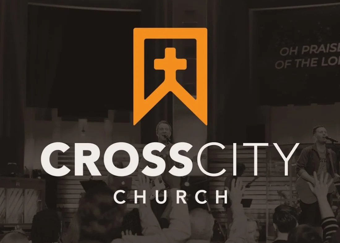 CrossCity Church logo with an orange cross bookmark symbol over a church interior with people raising their hands in worship.