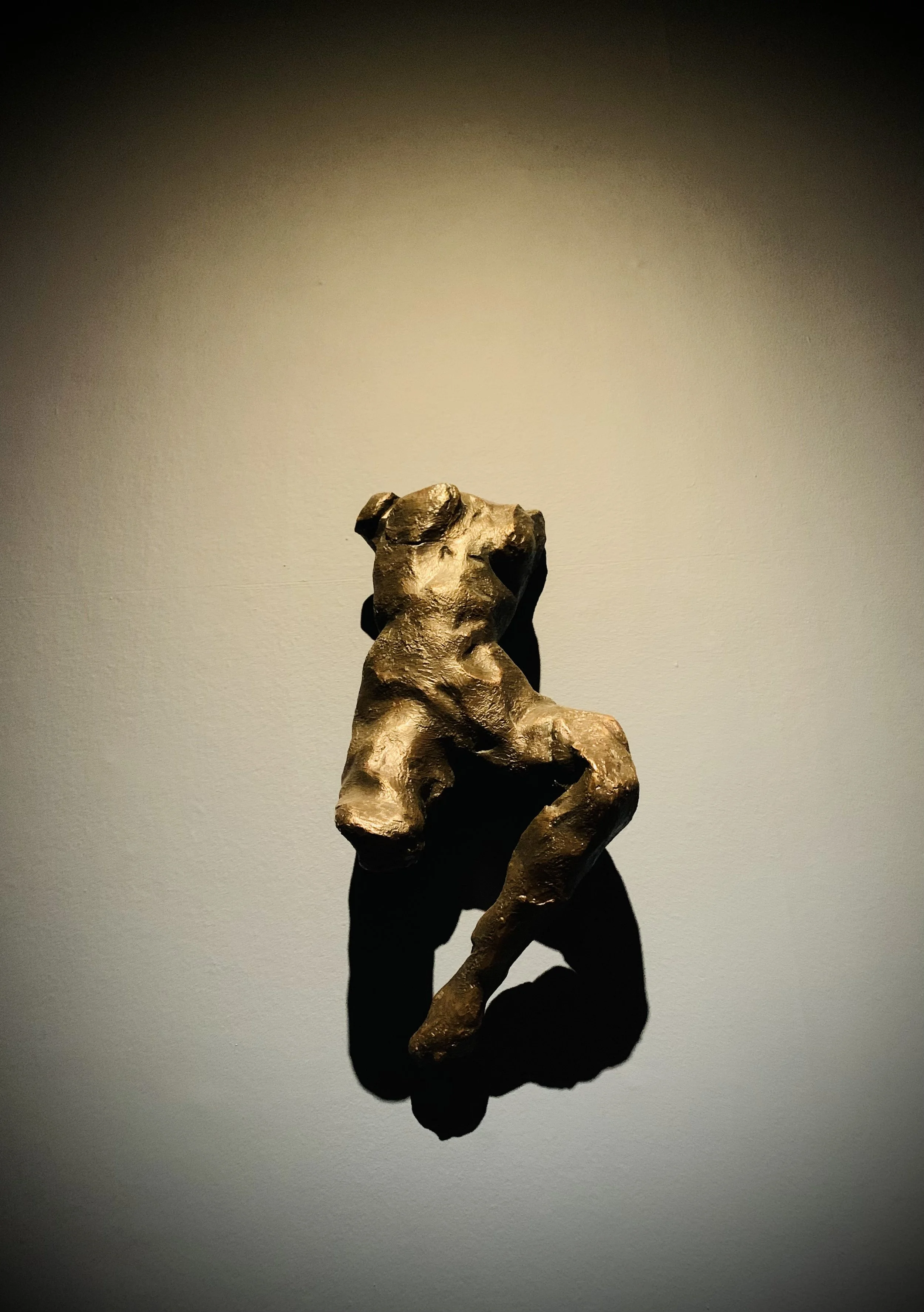 Female figure cast in bronze by Tracey Emin and mounted on a gallery wall