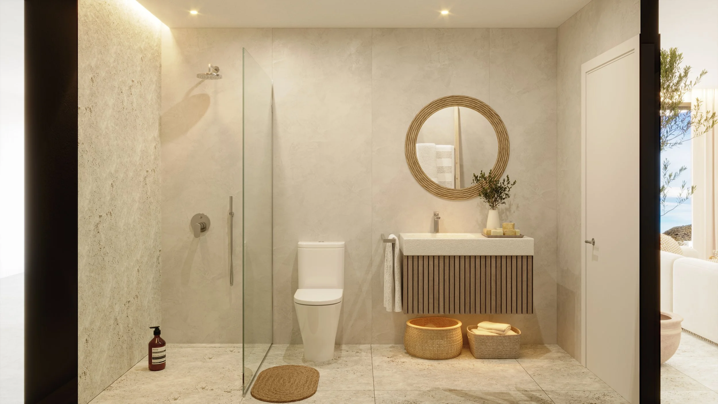 Modern bathroom with beige tiles, a walk-in shower with glass wall, a white toilet, wooden vanity with a round mirror, potted plant, and a wicker basket with folded towels. Natural light from a nearby window illuminates the space.