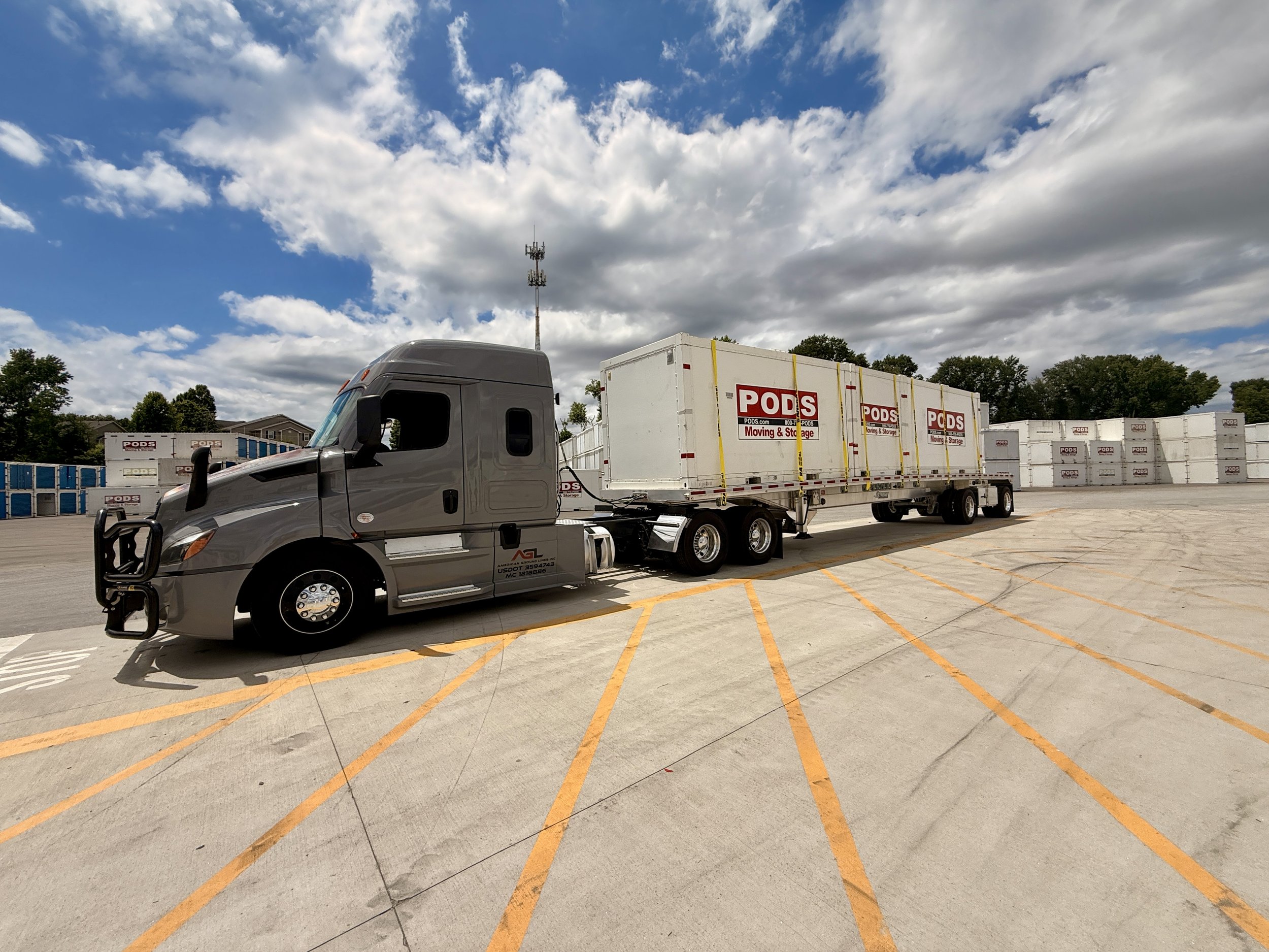 American Ground Lines truck hauling PODS containers on an open-deck trailer.