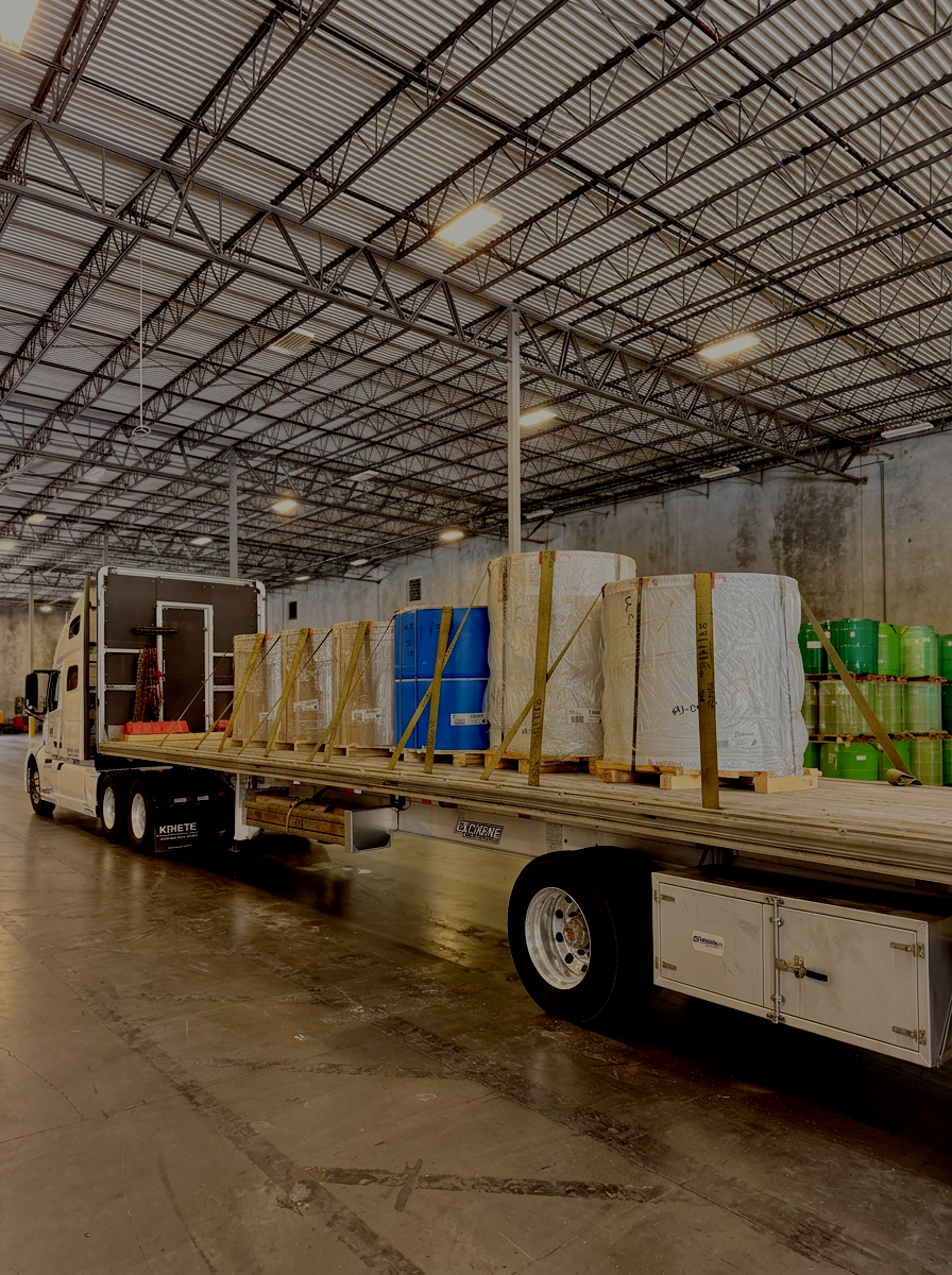 American Ground Lines flatbed transporting steel coils secured for shipment.