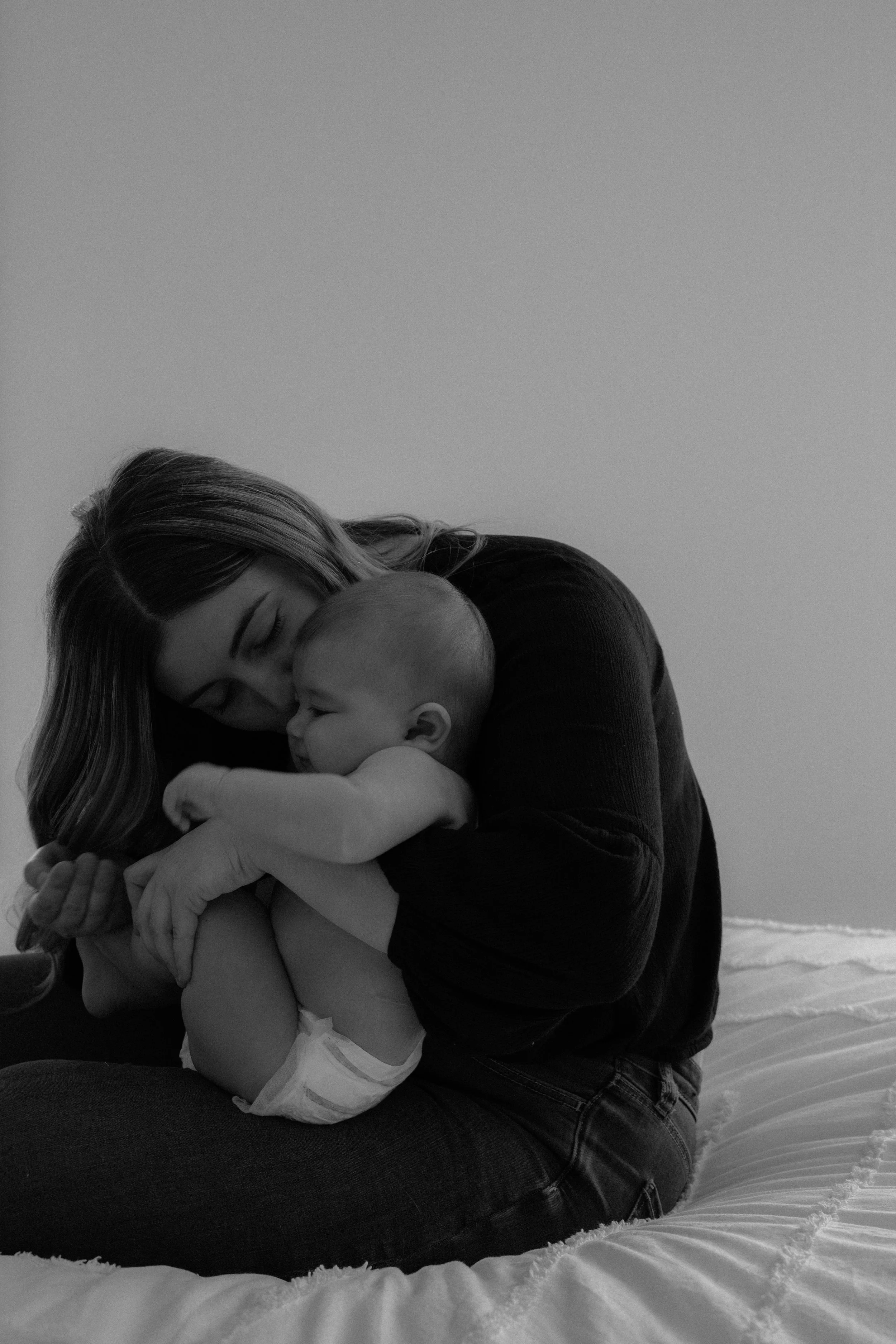 Maman embrassant tendrement son bébé lors d’une séance photo naturelle