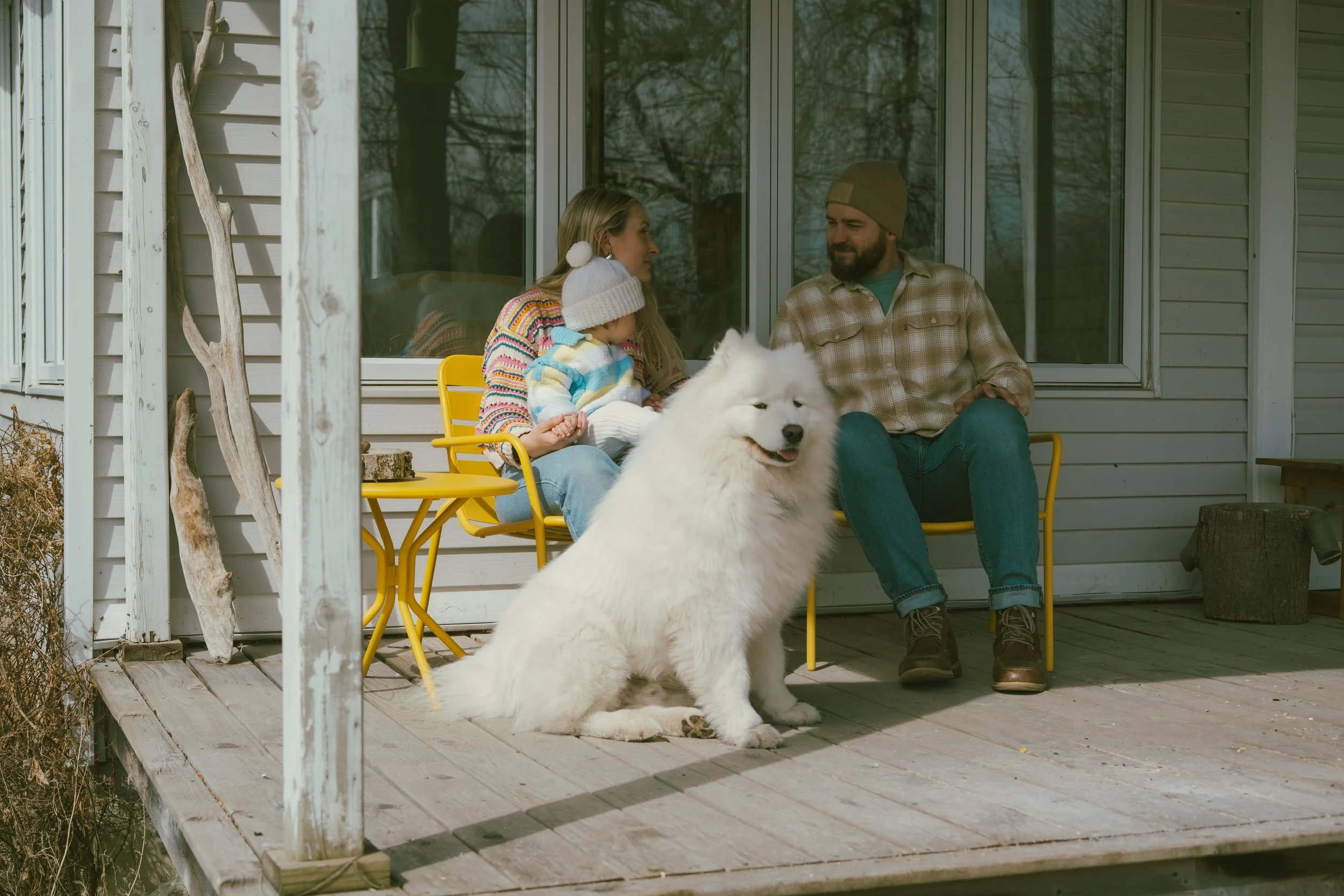 Famille partageant un moment naturel avec son chien sur la terrasse