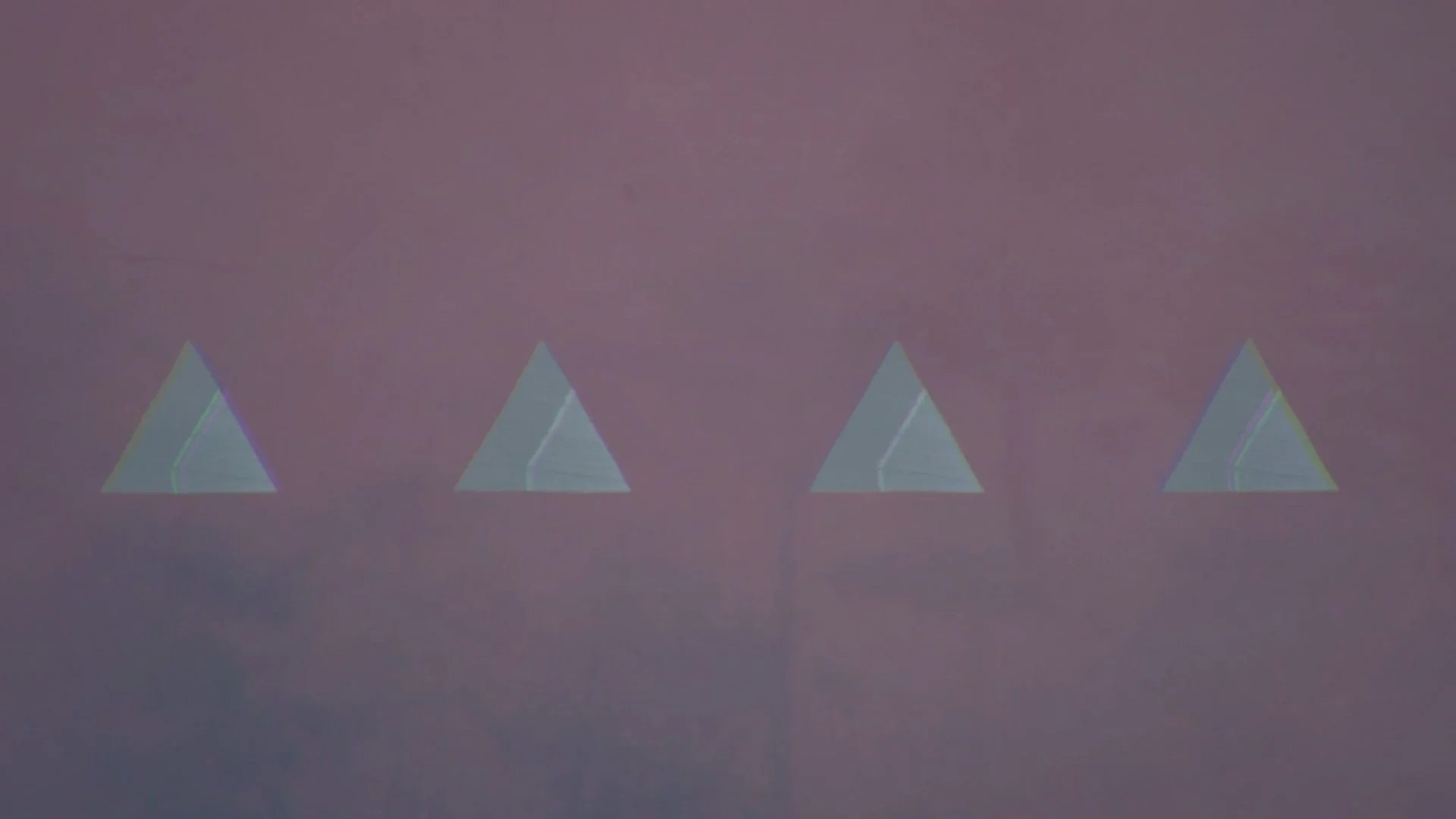 Four holographic pyramid shapes arranged in a row against a purple background.