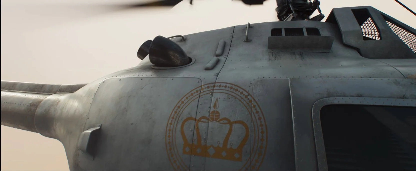 Close-up of a military helicopter with a crown emblem on its side.