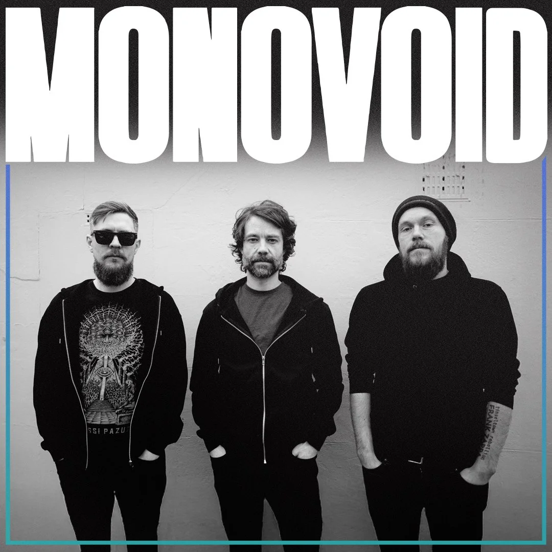 Black and white photo of three men standing against a wall with the word ''MOROVOID'' in large letters above them.