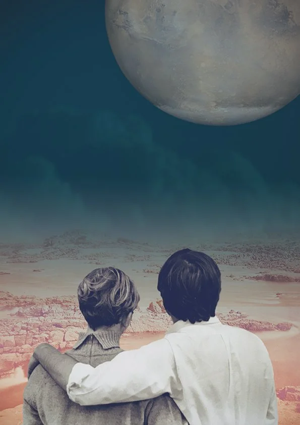 Two people standing arm in arm, looking at a large planet in the sky over a desert landscape.
