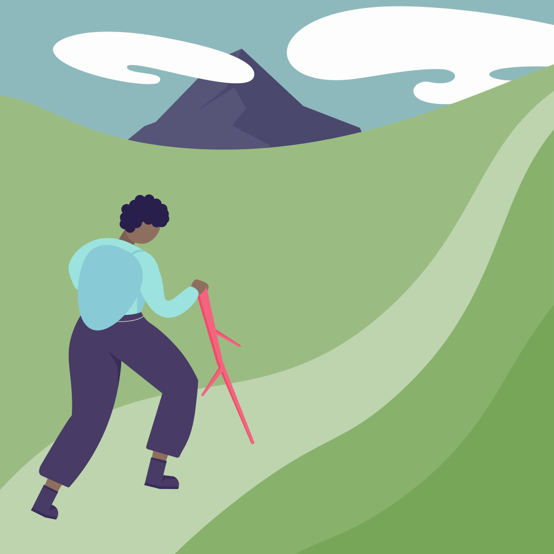 Person hiking up a trail on a grassy hillside with a mountain in the background.