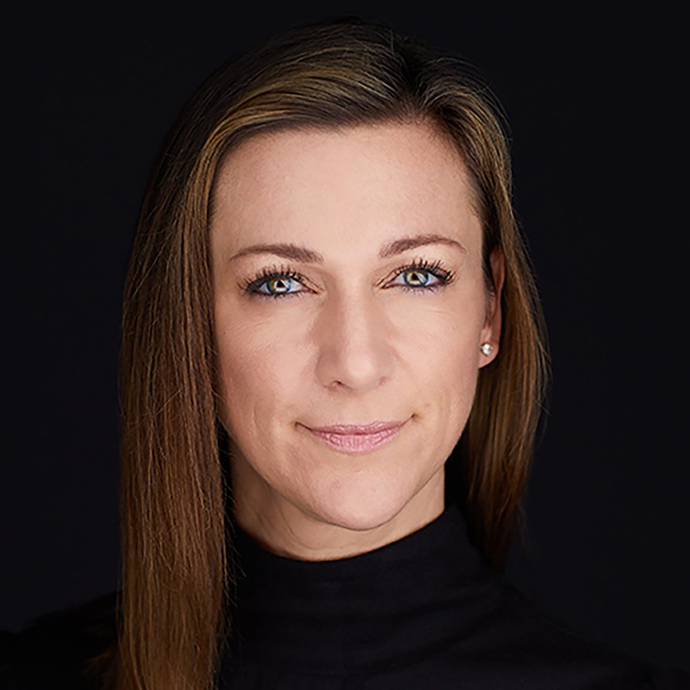 Headshot of a woman with straight, light brown hair, wearing a black turtleneck, against a black background.