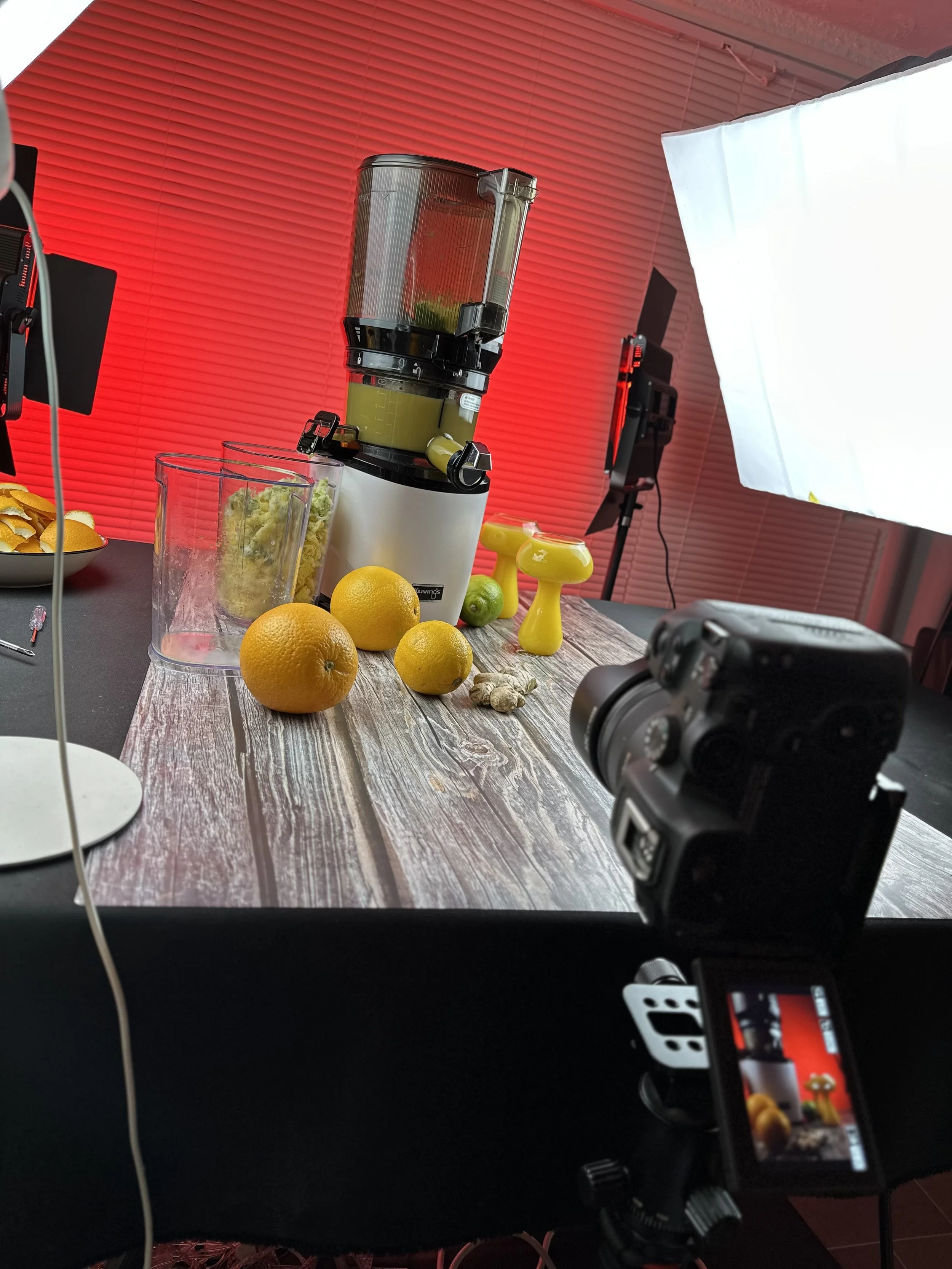 Foto eines Foto-Setups mit Küchenmaschine, Zitronen, Ingwer, Küchenutensilien und Beleuchtung in einem Studio