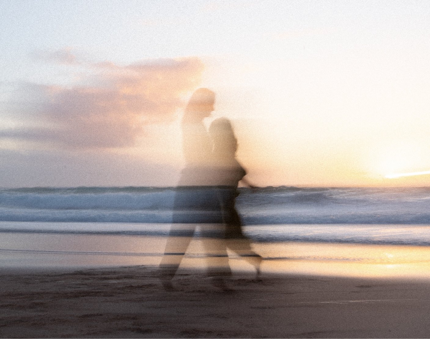 A blurry photo of a person walking on the beach at sunset, with multiple exposure effects creating a ghostly appearance against the ocean and sky.