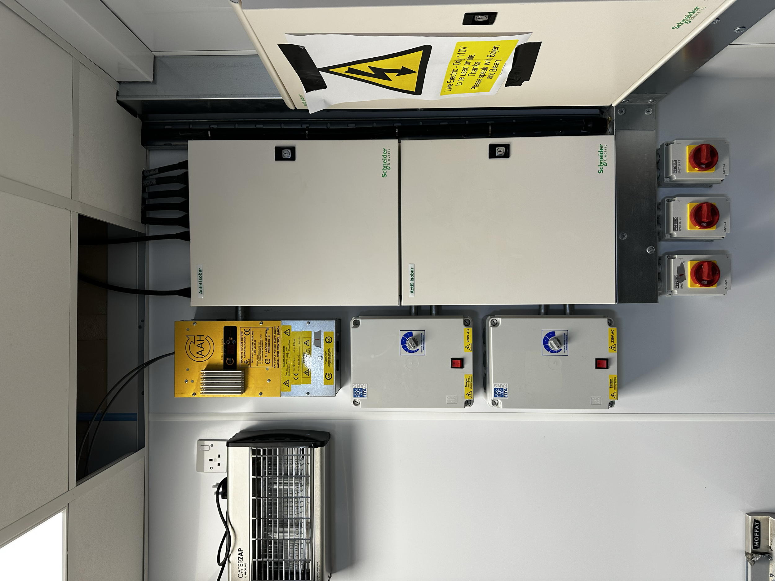     Industrial electrical control panel with protective devices and warning labels.