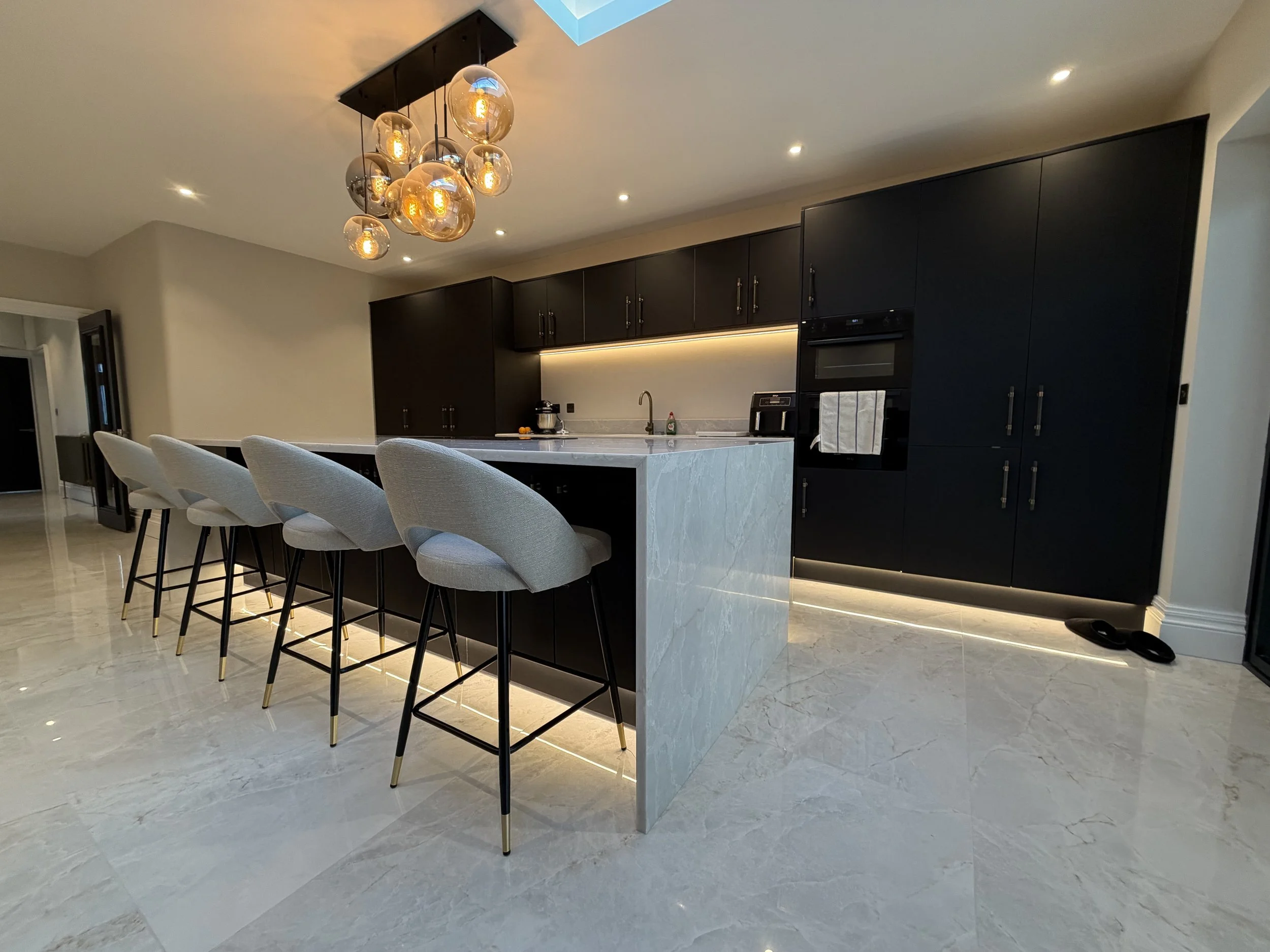 Completed domestic kitchen lighting installation with recessed spotlights and a pendant feature light.