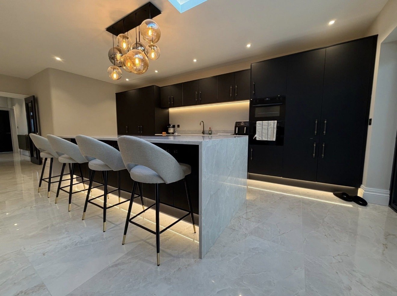     Completed kitchen lighting installation with recessed spotlights and pendant lights.