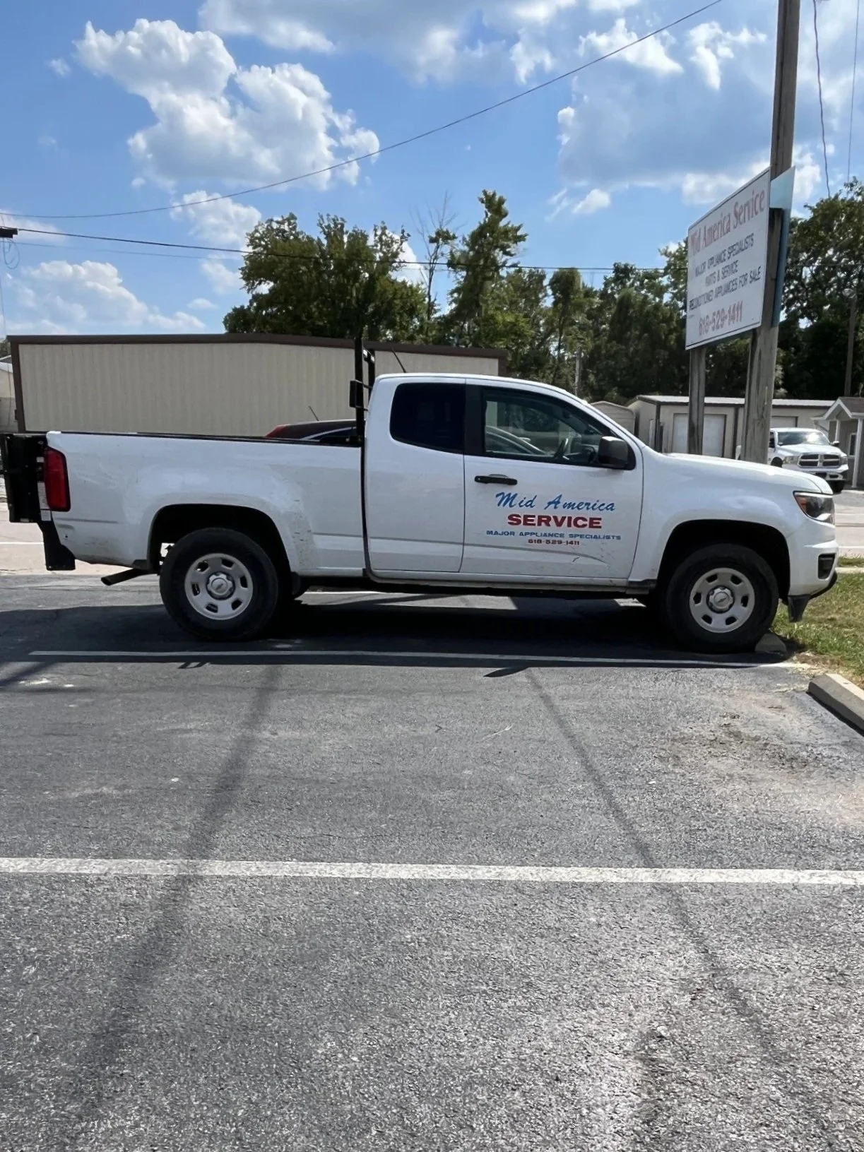 White pickup truck parked in a lot, with signage indicating it's for Mid America Service, a major appliance service company.